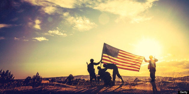 WWII Soldiers Raising The American Flag At Sunset.