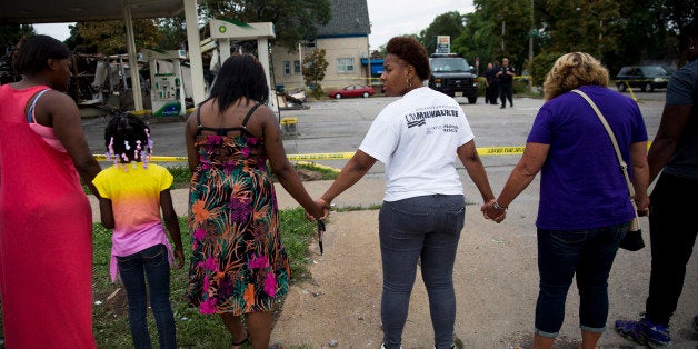 Jasmine Newson, 21, turns around while praying at a gas station that was destroyed by rioters after a fatal police shooting two days prior, on Monday, Aug. 15, 2016, in Milwaukee, Wis. (Armando L. Sanchez/Chicago Tribune/TNS via Getty Images)