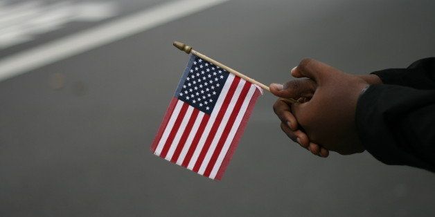 A small American flag held by African-American hands with a blurred background.