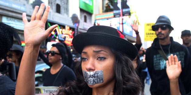 LOS ANGELES, CA - DECEMBER 6: People march on Hollywood Boulevard in protest of the decision in New York not to indict a police officer involved in the choke-hold death of Eric Garner on December 6, 2014 in the Hollywood section of Los Angeles, California. The march passes the tourist attraction of Hollywood and Highland where, by coincidence, police shot and killed a man in the intersection. Police say that he had a knife. (Photo by David McNew/Getty Images)