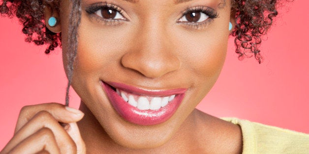 Portrait of an African American woman smiling over colored background