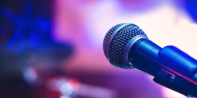 Microphone on the stage on violet background.