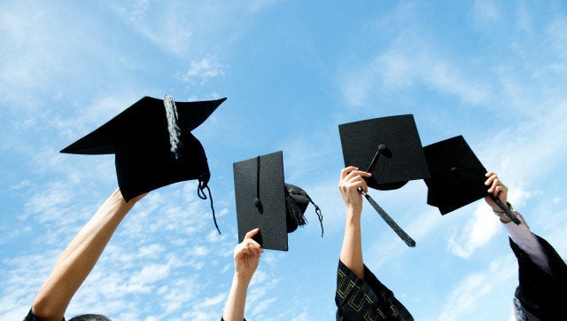 many hand holding graduation...