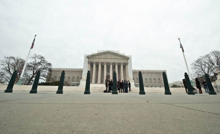 Tourists stand in front of the Supreme Court in Washington on March 24, 2013 as people begin lining up for the court's upcoming coming hearings on gay marriage. The justices will hear arguments on March 26 on California's Proposition 8 ban on same-sex marriage and on March 27 on the federal Defense of Marriage Act, which defines marriage as between one man and one woman. AFP PHOTO/Nicholas KAMM (Photo credit should read NICHOLAS KAMM/AFP/Getty Images)