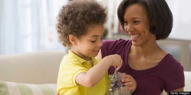 Mother and son holding jar of coins