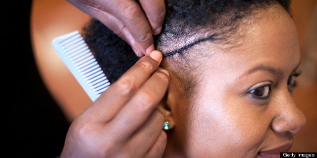 hair stylist braiding woman's hair