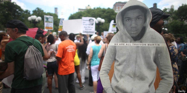 NEW YORK, NY - JULY 14: People gather at a rally honoring Trayvon Martin with his photo standing (R) while being held by a m