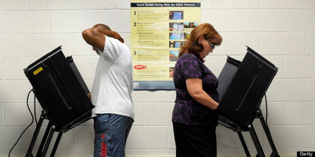 WILSON, NC - OCTOBER 18: Jack Bunn, 51, and Jane Cookson, 57, both of Wilson, North Carolina cast their votes at the Board of Elections early voting station on October 18, 2012 in Wilson, North Carolina. Today is the last day to register and the first day to vote for the election in North Carolina. (Photo by Sara D. Davis/Getty Images)