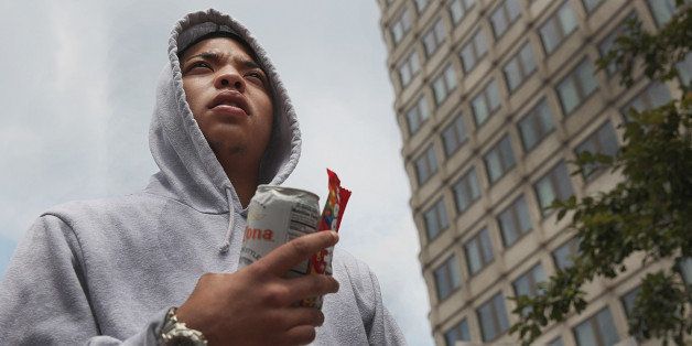 BOSTON - JULY 20: Symbolically clad in a hoodie and holding Skittles and a can of Arizona iced tea, Curtiss Boyd, 19, of Roslindale joined others in a rally in Government Center to protest the verdict in the Trayvon Martin case, Saturday, July 20, 2013. (Photo by Wendy Maeda/The Boston Globe via Getty Images)