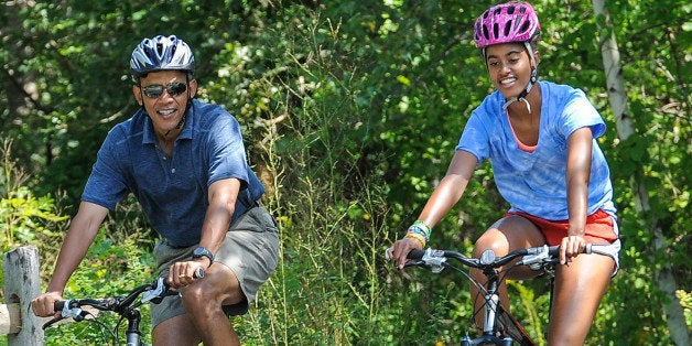 WEST TISBURY , MA - AUGUST 16: U.S. President Barack Obama (L) his daughter Malia Obama ride a bike during a vacation on Martha's Vineyard August 16, 2013in West Tisbury, Massachusetts. Obama and his family are on a weeklong vacation. (Photo by Rick Friedman-Pool/Getty Images)