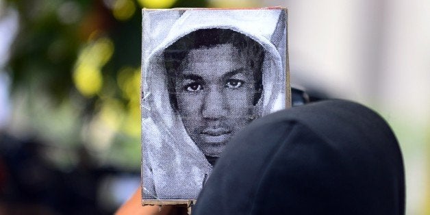 People demonstrate in front of the Federal Court House in Los Angeles on July 20, 2013 in suppport of slained teen Trayvon Martin (poster). Civil rights groups mobilized for protests in cities across the United States on Saturday amid charged emotions over the not-guilty verdict in the shooting death of unarmed black teenager Trayvon Martin. The demonstrations, which began in Miami, come a day after US President Barack Obama publicly identified with the slain 17-year-old and the deep frustrations felt among African Americans over the verdict. AFP PHOTO/Frederic J. BROWN (Photo credit should read FREDERIC J. BROWN/AFP/Getty Images)