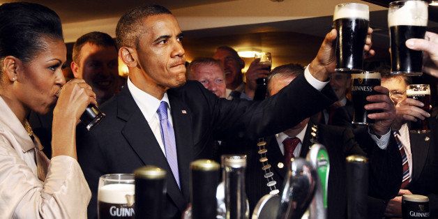 US President Barack Obama (2ndL) and First Lady Michelle Obama (L) sip Guinness at a pub as they visit Moneygall village in rural County Offaly, Ireland, where his great-great-great grandfather Falmouth Kearney hailed from, on May 23, 2011. Obama landed in Ireland on May 23, 2011 for a visit celebrating his ancestral roots, kicking off a four-nation European tour. AFP PHOTO/ JEWEL SAMAD (Photo credit should read JEWEL SAMAD/AFP/Getty Images)