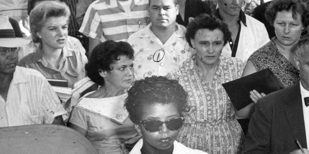 American teenager Elizabeth Eckford (center bottom, in suglasses) is followed by a crowd as she walks to school, Little Rock, Arkansas, September 23, 1957. Eckford and eight others, known as the Little Rock Nine had attempted to enroll in Little Rock Central High School and were initially prevented by Governor Orval Faubus who called on the National Guard to stop the school's integration. (Photo by PhotoQuest/Getty Images)