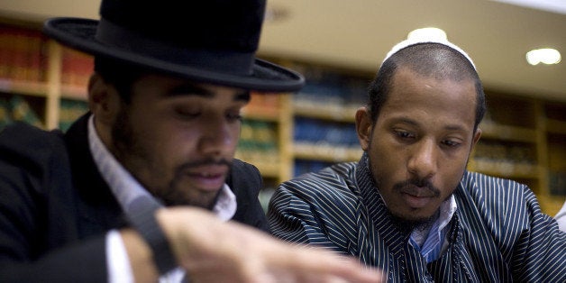 TO GO WITH AFP STORY BY SARA HUSSEIN US Jewish rapper Shyne (R) studies the Torah at the Esh Hatora yeshiva in Jerusalem on November 17, 2010. He might seem like a walking contradiction, but Shyne could be charting himself a highly unusual path back into the music business, 10 years after it seemed his short-lived but promising rap career was over. AFP PHOTO /LIOR MIZRAHI (Photo credit should read LIOR MIZRAHI/AFP/Getty Images)