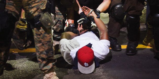 FERGUSON, MO - AUGUST 19: Police arrest a demonstrator protesting the killing of teenager Michael Brown on August 19, 2014 in Ferguson, Missouri. Brown was shot and killed by a Ferguson police officer on August 9. Despite the Brown family's continued call for peaceful demonstrations, violent protests have erupted nearly every night in Ferguson since his death. (Photo by Scott Olson/Getty Images)