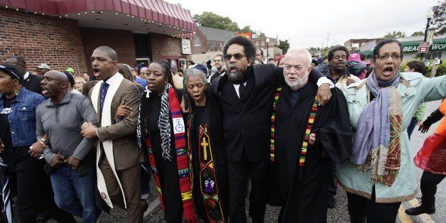 Professor Cornel West (C) along with clergy members and other demonstrators protest for the shooting of Michael Brown as they march to the Ferguson Police Station October, 13 2014 in Ferguson, Missouri. Civil rights organizations, protest groups and people from around the country were protesting the August 9 shooting of Brown, which involved Ferguson Police officer Darren Wilson and other killings of black youths at the hands of police officers. AFP PHOTO/Joshua LOTT (Photo credit should read Joshua LOTT/AFP/Getty Images)