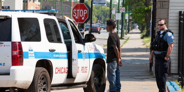 CHICAGO, IL - JUNE 9: Chicago police wearing bulletproof vests handcuff a young man temporarily while they check his information in the Roseland neighborhood, on June 9, 2014 in Chicago, Illinois. He was eventually let go. Roseland is one of the most crime-ridden neighborhoods in the area. The Chicago Police Department is trying new policing methods to help fight crime. (Photo by Melanie Stetson Freeman/The Christian Science Monitor via Getty Images)