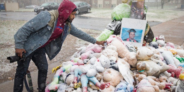 FERGUSON, MO - NOVEMBER 16: Aaron Jeremiah, of Houston, leaves a memento at a memorial near the location where 18-year-old Michael Brown was shot on November 16, 2014 in Ferguson, Missouri. Brown was killed by Darren Wilson, a Ferguson police officer, on August 9. Residents in the area are on edge as they wait to hear if the grand jury will vote to indict Wilson for the shooting. The decision is expected sometime in November. (Photo by Scott Olson/Getty Images)