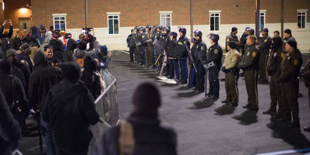FERGUSON, MO - NOVEMBER 20: Police confront demonstrators protesting the shooting death of 18-year-old Michael Brown outside the police station on November 20, 2014 in Ferguson, Missouri. At least three people were arrested during the protest. Brown was killed by Darren Wilson, a Ferguson police officer, on August 9. A grand jury is expected to decide this month if Wilson should be charged in the shooting. (Photo by Scott Olson/Getty Images)