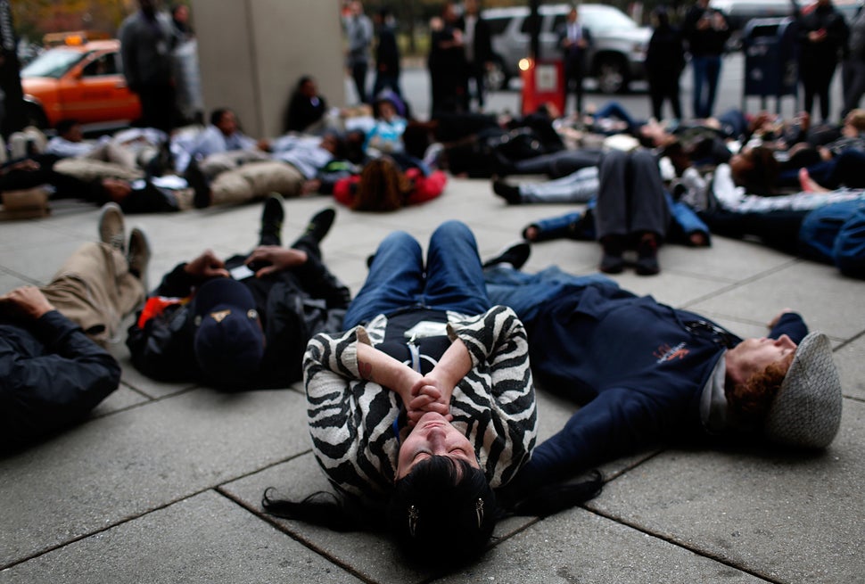 Joy Cooney takes part in a "die-in" during a protest outside the Office of Police Complaints as part of a planned "28 Hours f