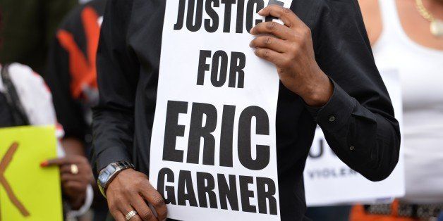 Demonstrators rally against police brutality in memory of Eric Garner on August 23, 2014 in Staten Island, New York. The New York City medical examiner's office ruled that Garner, the 43-year-old father of six, died from a chokehold and chest compressions while being arrested by the police on July 17, 2014. AFP PHOTO/Stan Honda (Photo credit should read STAN HONDA/AFP/Getty Images)