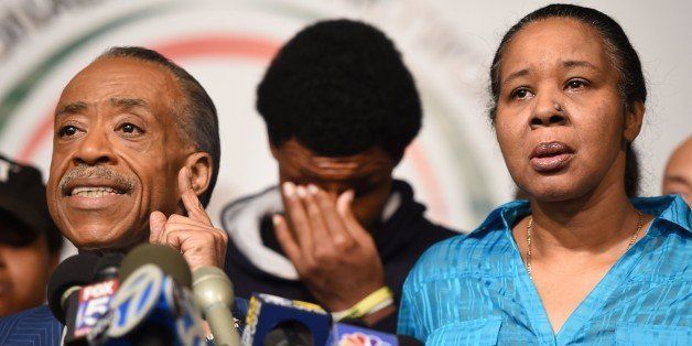 Rev. Al Sharpton (L), President of the National Action Network, Esaw Garner (R), widow of Eric Garner, and son Emory Garner (C) hold a press conference December 3, 2014 in New York, after a grand jury decided not to charge a white police officer in the choking death of Eric Garner, a black man, days after a similar decision sparked renewed unrest in Missouri. Eric Garner died after being placed in a chokehold by New York police Officer Daniel Pantaleo while being arrested on suspicion of selling untaxed cigarettes in Staten Island. AFP PHOTO / Timothy A. CLARY (Photo credit should read TIMOTHY A. CLARY/AFP/Getty Images)