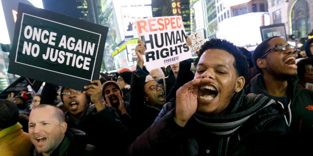 Protestors shout at Times Square after it was announced that the New York City police officer involved in the death of Eric Garner is not being indicted, Wednesday, Dec. 3, 2014, in New York. A grand jury cleared the white New York City police officer Wednesday in the videotaped chokehold death of Garner, an unarmed black man, who had been stopped on suspicion of selling loose, untaxed cigarettes, a lawyer for the victim's family said. A video shot by an onlooker and widely viewed on the Internet showed the 43-year-old Garner telling a group of police officers to leave him alone as they tried to arrest him. The city medical examiner ruled Garner's death a homicide and found that a chokehold contributed to it. (AP Photo/Julio Cortez)