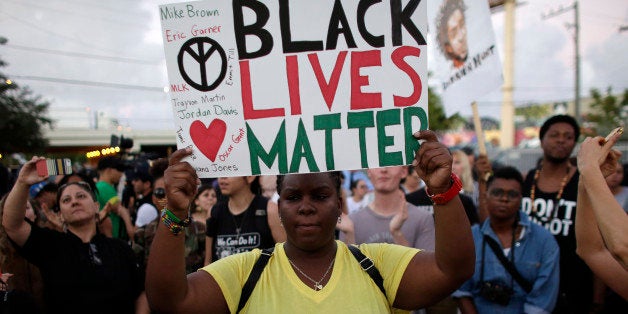 Desiree Griffiths, 31, of Miami, holds up a sign saying "Black Lives Matter", with the names of Michael Brown and Eric Garner, two black men recently killed by police, during a protest Friday, Dec. 5, 2014, in Miami. People are protesting nationwide against recent decisions not to prosecute white police officers involved in the killing of black men. (AP Photo/Lynne Sladky)