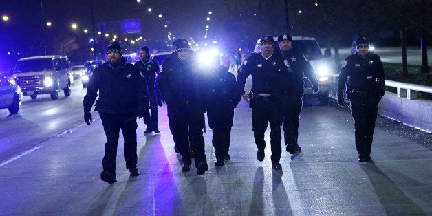 Members of the Chicago Police Department walk north on Lake Shore Drive as protesters march in Chicago following the announce