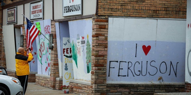 FERGUSON, MO - DECEMBER 02: Protestors draw graffiti on the walls of shops, were set fire during riots erupted after the Grand Jury decided not to indict white Police Officer Daren Wilson in the shooting death of black 18-year old Michael Brown in Ferguson, to show their reactions about Grand Jury's decision at West Florissant Avenue in Ferguson, Missouri on December 02, 2014. (Photo by Cem Ozdel/Anadolu Agency/Getty Images)