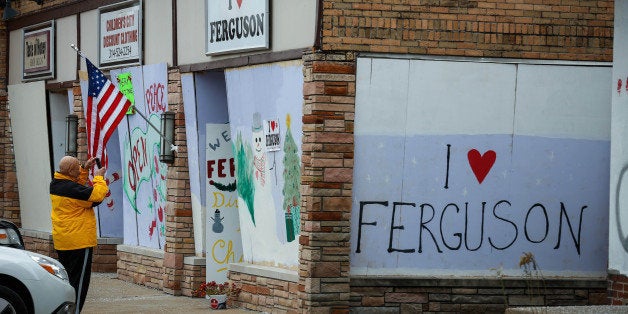 FERGUSON, MO - DECEMBER 02: Protestors draw graffiti on the walls of shops, were set fire during riots erupted after the Grand Jury decided not to indict white Police Officer Daren Wilson in the shooting death of black 18-year old Michael Brown in Ferguson, to show their reactions about Grand Jury's decision at West Florissant Avenue in Ferguson, Missouri on December 02, 2014. (Photo by Cem Ozdel/Anadolu Agency/Getty Images)