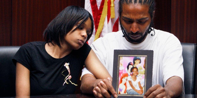 FILE -- In this May 18, 2010 file photo, Dominika Stanley and Charles Jones hold a photo of their 7-year-old daughter Aiyana Jones in an attorney's office in Southfield, Mich. Aiyana was killed while she slept on a couch by a Detroit police officer accused of handling his gun recklessly during a frantic search for a murder suspect in 2010. (AP Photo/Carlos Osorio, File)