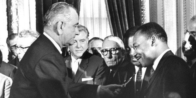 President Lyndon Johnson hands a souvenir pen to the Reverend Martin Luther King Jr after signing the Voting Rights Bill at the US Capital, Washington DC, 1965. (Photo by PhotoQuest/Getty Images)