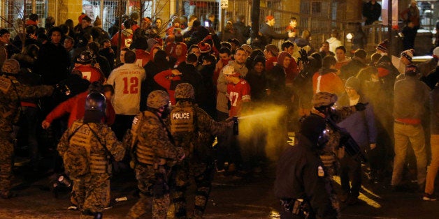 Police officers try to disperse the crowd of Ohio State fans trying to block High Street in Columbus, Ohio, as they celebrate the Buckeye's 42-20 win over Oregon following the National Championship football game between Ohio State and Oregon outside of Ohio State University in Columbus, Ohio, Monday, Jan. 12, 2015. (AP Photo/Paul Vernon)