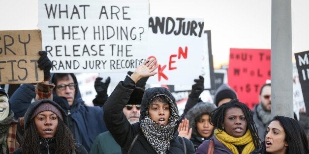 NEW YORK, UNITED STATES - JANUARY 15: Protesters hold banners and shout slogans at the outside of the 120th Police Precinct Station, during a demonstration continues with a candlelight vigil in memory of the Eric Garner, died in New York's Staten Island on 17th of July 2014 after a police officer put him in a chokehold due to an incident, in New York City, NY, United States on January 15, 2015. After the incident, grand jury had not charged the New York City police officer. (Photo by Cem Ozdel/Anadolu Agency/Getty Images)