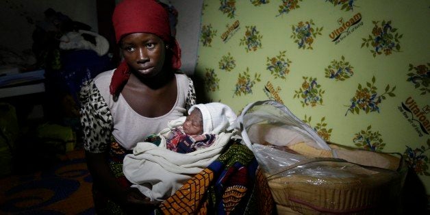 Maria Mala, a displaced woman with her new born baby Namadi, who was born Thursday morning rest at the camp for internally displaced people in Yola, Nigeria, Thursday Nov. 27, 2014. Thousands of people have fled their homes in recent times due to Boko Haram attacks. (AP Photo/Sunday Alamba )