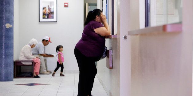 In this July 12, 2012 photo, a woman stands at the registration window at Nuestra Clinica Del Valle in San Juan, Texas. About 85 percent of those served at the clinic are uninsured. Texas already has one of the nationâs most restrictive Medicaid programs, offering coverage only to the disabled, children and parents who earn less than $2,256 a year for a family of three. Without a Medicaid expansion, the stateâs working poor will continue relying on emergency rooms _ the most costly treatment option _ instead of primary care doctors. The Texas Hospital Association estimates that care for uninsured patients cost hospitals in the state $4.5 billion in 2010. (AP Photo/Eric Gay)