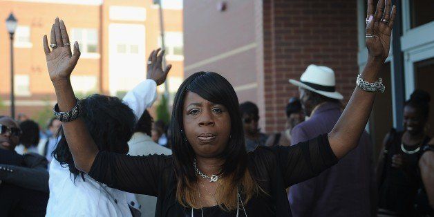 A woman gestures as she enters the funeral of slain 18-year old teenager Michael Brown Jr. at Friendly Temple Missionary Baptist Church in St. Louis, Missouri on August 25, 2014. Michael Brown, the black teen whose shooting death by a white policeman ignited protests and a national debate on race, was eulogized at a cathartic funeral service Monday as a victim of abusive policing whose untimely death demands justice. Brown's family said goodby to their 18-year-son with gospel hymns and fiery orations that rocked a packed Baptist church not far from the Ferguson suburb where he was killed August 9. AFP PHOTO / Michael B. THOMAS (Photo credit should read Michael B. Thomas/AFP/Getty Images)