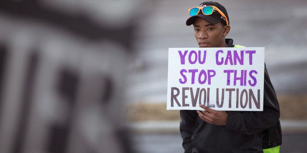 FERGUSON, MO - JANUARY 19: Demonstrators protest outside the Ferguson police department as they remember Michael Brown on Martin Luther King Jr. Day January 19, 2015 in Ferguson, Missouri. Brown, an unarmed black teenager, was shot and killed by Darren Wilson, a white Ferguson police officer, August 9, 2014. His death caused months of sometimes violent protests in the St. Louis area and sparked nationwide outcry against use of excessive force by police. (Photo by Scott Olson/Getty Images)