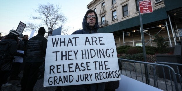 NEW YORK, UNITED STATES - JANUARY 15: Protesters hold banners and shout slogans at the outside of the 120th Police Precinct Station, during a demonstration continues with a candlelight vigil in memory of the Eric Garner, died in New York's Staten Island on 17th of July 2014 after a police officer put him in a chokehold due to an incident, in New York City, NY, United States on January 15, 2015. After the incident, grand jury had not charged the New York City police officer. (Photo by Cem Ozdel/Anadolu Agency/Getty Images)