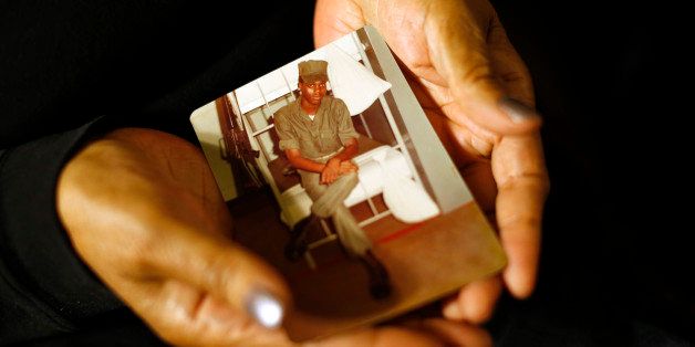 In this March 12, 2014 photo, Alma Murdough holds a photo of her son, Jerome, at her home in the Queens borough of New York. Jerome Murdough, a mentally ill, homeless former Marine arrested for sleeping in the roof landing of a New York City public housing project during one of the coldest recorded winters in city history, died last month in a Rikers Island jail cell that multiple city officials say was at least 100 degrees when his body was discovered. Murdough, 56, was found dead in his cell in a mental observation unit in the early hours of Feb. 15, after excessive heat, believed to be caused by an equipment malfunction, redirected itâs flow to his upper-level cell, the officials said. (AP Photo/Jason DeCrow)