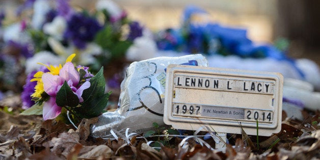 A small metal placard marks the grave of Lennon Lacy Sunday, Dec. 14, 2014, at Old Shaw-Lacy Field Cemetery in Bladenboro, N.C. Lennon Lacy, a 17-year-old black teenager, was found dead on Aug. 29, 2014, hanging from a swing set in a trailer park in the rural community. Police ruled the death a suicide, but his family believe it was murder.