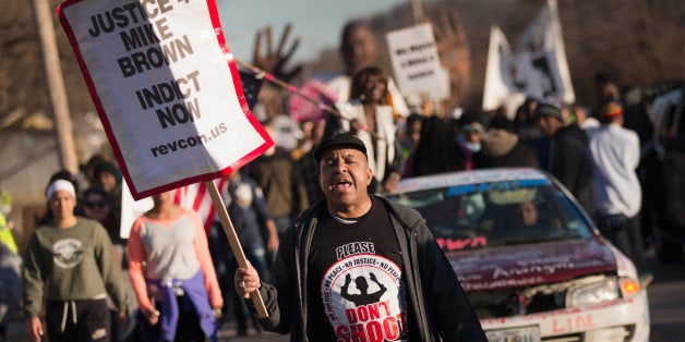 FERGUSON, MO - JANUARY 19: Demonstrators remember Michael Brown with a Martin Luther King Jr. Day march from the apartment complex where he was killed to the Ferguson police station on January 19, 2015 in Ferguson, Missouri. Brown, an unarmed black teenager, was shot and killed by Darren Wilson, a white Ferguson police officer, August 9, 2014. His death caused months of sometimes violent protests in the St. Louis area and sparked nationwide outcry against use of excessive force by police. (Photo by Scott Olson/Getty Images)