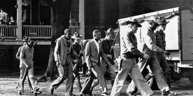 FILE - In this April 6, 1933 file photo, four of the Scottsboro Boys prisoners are escorted by heavily-armed guards into the Decatur, Ala., courtroom. Now that the Alabama Legislature is allowing posthumous pardons for the Scottsboro Boys, the nine African-American youths wrongfully convicted of raping two caucasian women more than 80 years ago, there is still much work to be done before their names are officially cleared. (AP Photo/File)