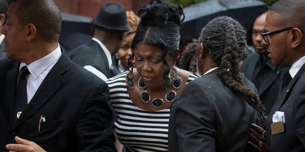 Sylvia Palmer, mother of Akai Gurley, leaves the funeral of her son at Brown Baptist Memorial Church, Saturday, Dec. 6, 2014, in the Brooklyn borough of New York. Gurley was shot to death by rookie NYPD officer Peter Liang in a pitch black hallway of the Louis Pink Houses public housing complex in November. (AP Photo/John Minchillo)