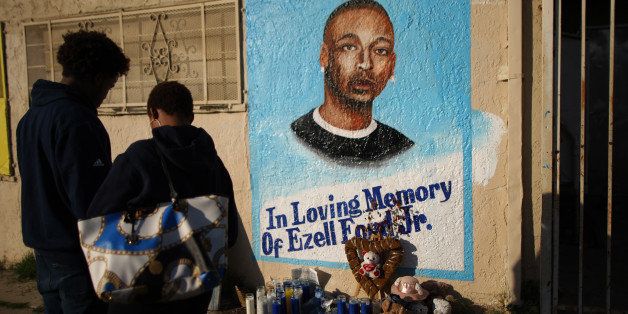 LOS ANGELES, CA - DECEMBER 29: People look at a mural of Ezell Ford, a 25-year-old mentally ill black man, at the site where he was shot and killed by two LAPD officers in August, on December 29, 2014 in Los Angeles, California. The long-awaited autopsy report, which was put on a security hold at the request of police and ordered by L.A. Mayor Eric Garcetti to be made public before the end of 2014, was released December 29. (Photo by David McNew/Getty Images)
