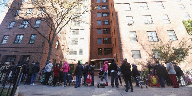 NEW YORK, NY - NOVEMBER 04: People wait on line to collect food at the Jacob Riis housing projects in Manhattanâs East Village on the first Sunday following Superstorm Sandy on November 4, 2012 in New York City. The projects were flooded during the storm. With the death toll currently over 100 and millions of homes and businesses without power, the US east coast is attempting to recover from the effects of floods, fires and power outages brought on by Superstorm Sandy. (Photo by Mario Tama/Getty Images)