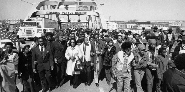 Aided by Father James Robinson, Mrs. Coretta Scott King, widow of Dr. Martin Luther King, Jr., center, and John Lewis of the Voter Education Project, a crowd estimated by police at 5,000, march across the Edmund Pettus Bridge from Selma, Alabama Saturday, March 8, 1975. The march commemorated the decade since the violent struggle for voting rights began in 1965 with âBloody Sundayâ at the bridge as police tried to stop a march to Montgomery. (AP Photo)