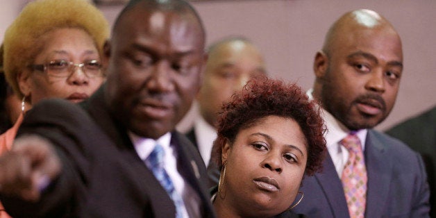 Samaria Rice, center, the mother of Tamir Rice, a 12-year-old boy fatally shot by a Cleveland police officer, watches the video of Tamir's shooting during a news-conference Tuesday, March 3, 2015, in Cleveland. Attorney Benjamin Crump, left, and attorneys Walter Madison, right, watch. Rice and her attorneys talked about the city's response to the lawsuit, a day after Cleveland Mayor Frank Jackson apologized for wording in a court document in which the city said the boy died as a result of his own actions. (AP Photo/Tony Dejak)