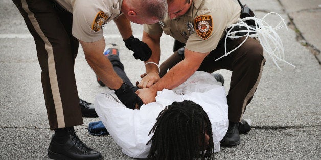 FERGUSON, MO - SEPTEMBER 10: Police arrest a demonstrator during a protest along Interstate Highway 70 on September 10, 2014 near Ferguson, Missouri. The demonstrators had planned to shut down I70 but their efforts were thwarted by a large contingent of police from several area departments. Ferguson, in suburban St. Louis, is recovering from nearly two weeks of violent protests that erupted after teenager Michael Brown was shot and killed by Ferguson police officer Darren Wilson last month. (Photo by Scott Olson/Getty Images)